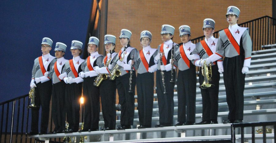 The band students who chose to walk off stand with arms linked in the student section. 