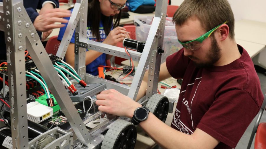 Senior Joel Neppl examines the wiring of the team robot. 