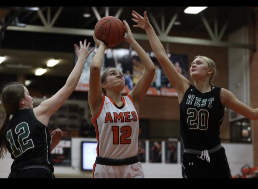 Ames Senior Leah Tietjens goes for a shot guarded by two  West players