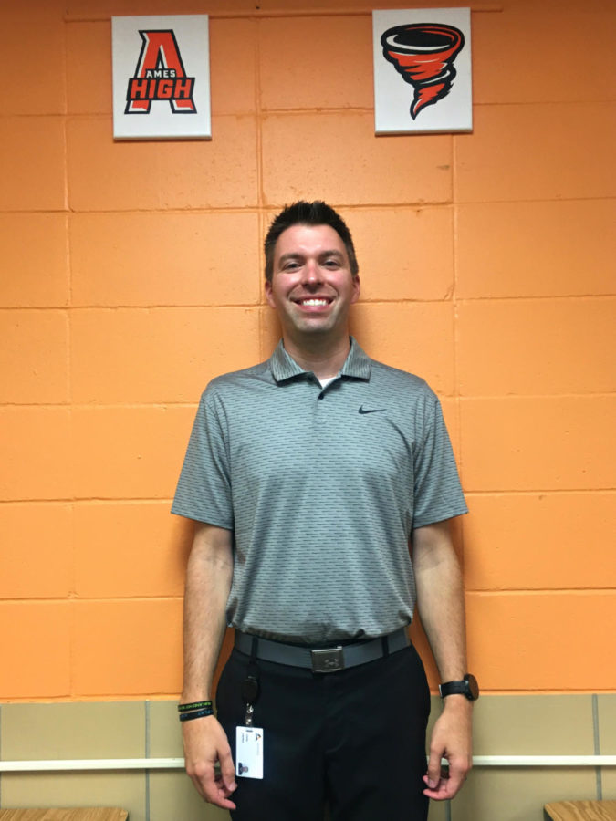 Mr. Harken poses with some AHS logos he painted for his classroom. 