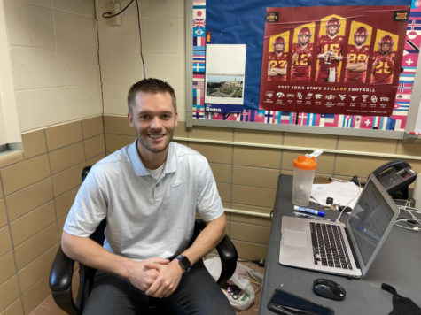 Mr. Landhauser sitting at his desk in his classroom. 