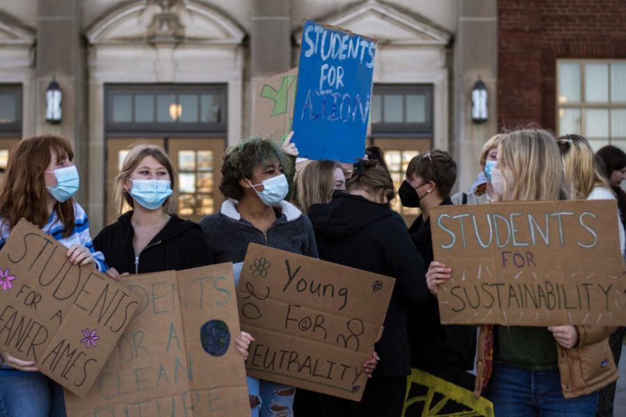 Students line up outside Ames city hall with signs demanding climate action. 