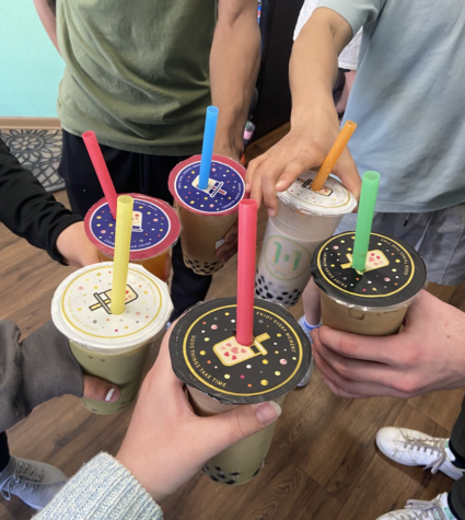 Ames High WEB staff members hold their drinks from 1+1 in a circle. Photo by Lily Lupardus. 