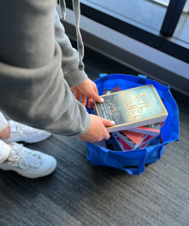 The Web’s Editor-in-Chief Chantal Eulenstein looks through a pile of books English teacher James Webb has pulled from his shelves and placed in cloth bags in the corner of his room. Most of the books were new and intended for this year’s AP literature classes. 