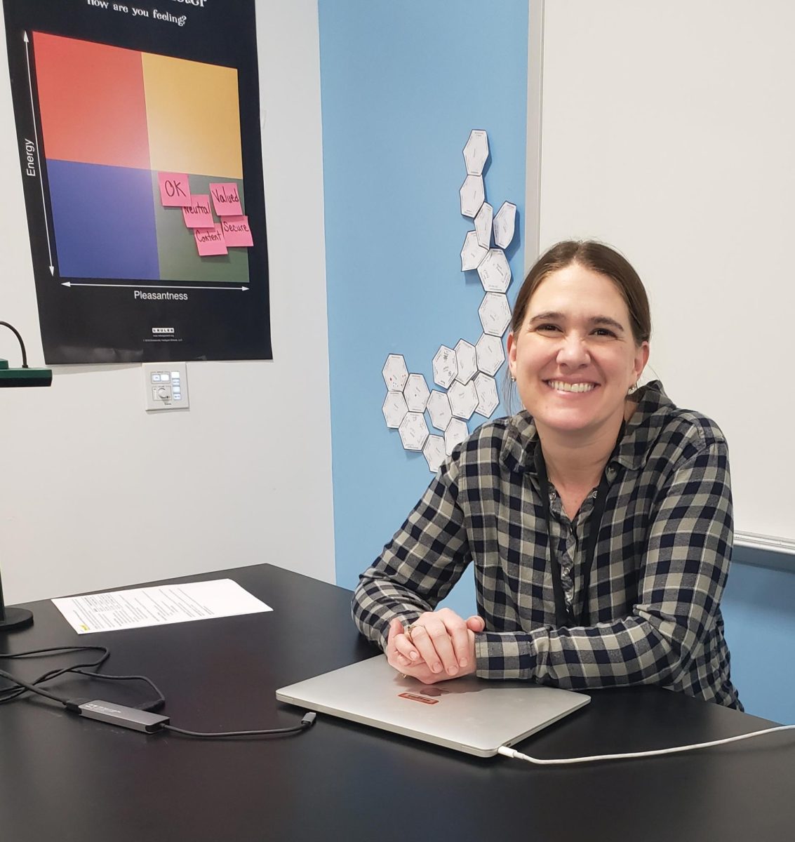 Elizabeth Brenneman sits and poses at her desk. Brenneman seeks to create an environment in her classroom where all students, regardless of skill level, can feel empowered. 