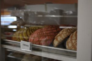 Conchas, a Mexican sweet bread topped with colored sugar, sit in a display case in the center of Rinconcito Hispano's grocery section. They are one of the many hispanic specialty items sold at the store. 