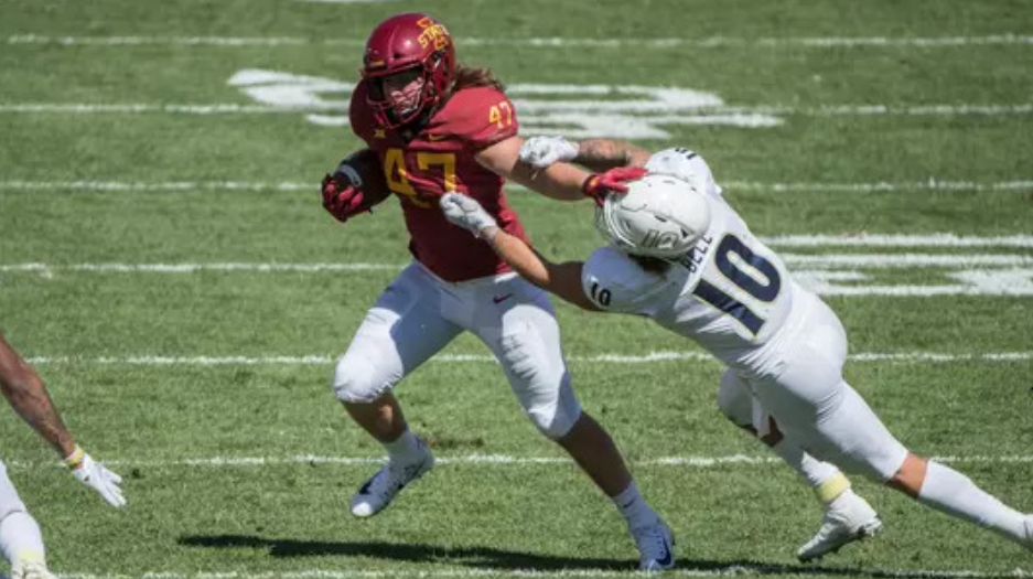 Sam Stiff-arming his opponent, hitting the Heisman pose.