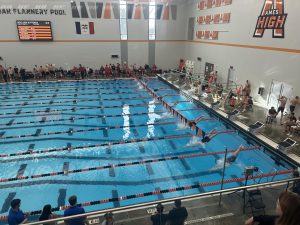 Swimmers dive from their blocks at the start of the 100 yard butterfly.